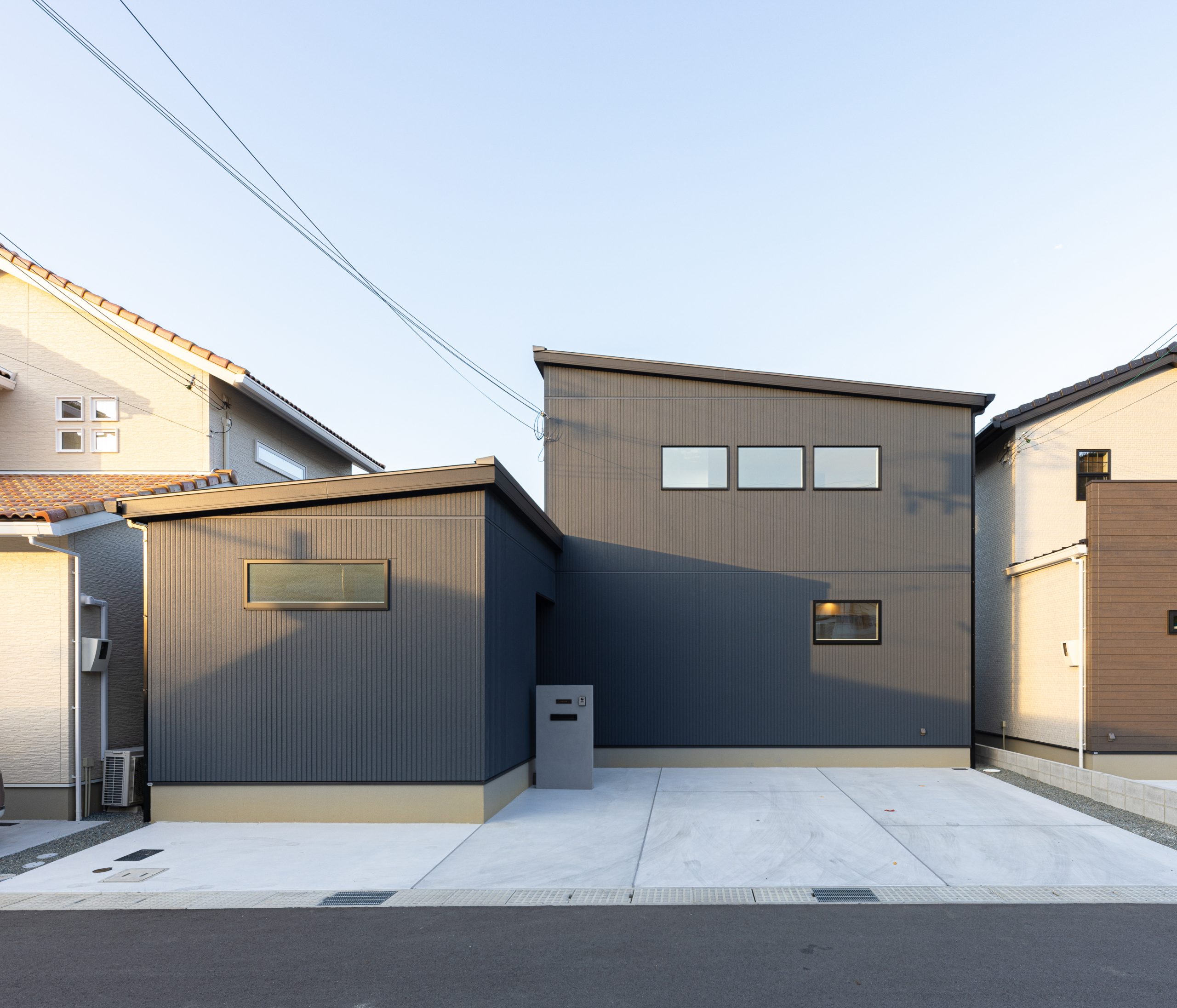 洗練された広々駐車場のあるモダンな黒い外観